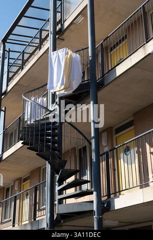 La buanderie est suspendue pour sécher à l'extérieur sur l'escalier en colimaçon entre les balcons d'un immeuble d'appartements Banque D'Images
