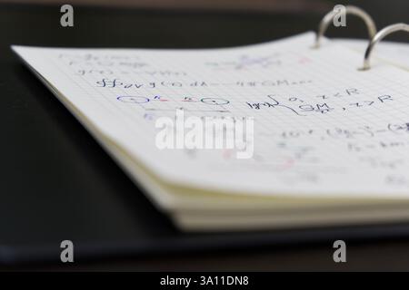 Un carnet ouvert révèle des équations mathématiques complexes et des graphiques colorés, accompagnés d'un luxueux stylo doré Banque D'Images