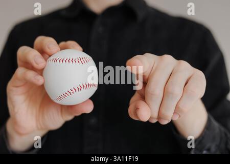 Homme tenant le baseball et pointant son doigt vers la caméra de près Banque D'Images