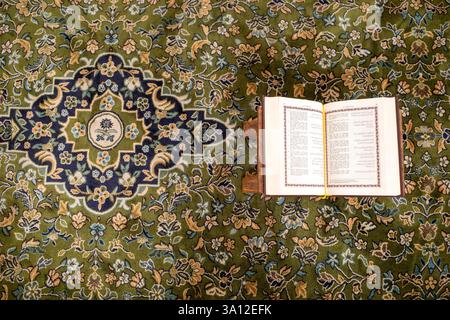Un livre sacré ouvert du Coran sur un tapis vert à la mosquée du Prophète, Masjid Nabawi dans la ville de Médine, en Arabie Saoudite. Banque D'Images