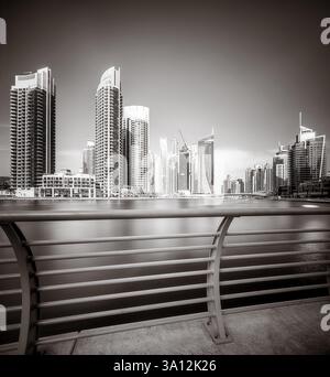 Gratte-ciel et pont sur l'eau, style noir et blanc, fond de ville, Dubai Marina Bay UAE Banque D'Images