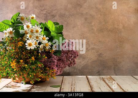 Un arrangement floral d'herbes médicinales sauvages sur une table en bois dans un panier, un bouquet de moût de John, origan, menthe, camomille, une collection de nous Banque D'Images
