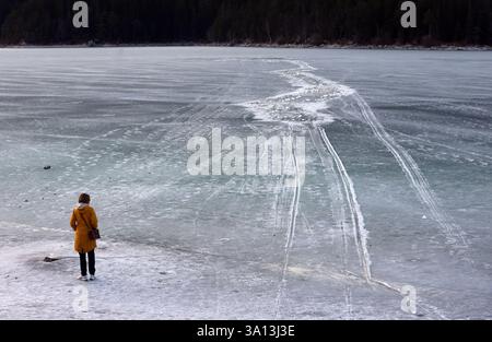 Grainau, Allemagne. 06 mars 2025. Une femme se tient sur la rive du lac gelé Eibsee, près de l’endroit où plusieurs personnes avaient brisé la glace dans l’après-midi. Crédit : Karl-Josef Hildenbrand/dpa/Alamy Live News Banque D'Images