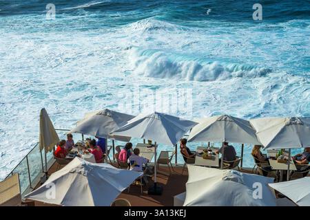 Les gens apprécient la vue sur l'océan Atlantique depuis une terrasse sur le toit à Porto Moniz, Madère, Portugal Banque D'Images