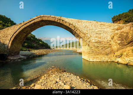 Majestueuse arche en pierre d'Ura e Katiut enjambant Langarica Canyon à Bënjë, Përmet : le "pont du juge" intemporel de l'Albanie au milieu des vues montagneuses et immaculées Banque D'Images