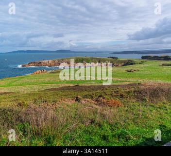 Une vue panoramique à couper le souffle sur la côte accidentée près De A Coruña, Espagne, mettant en valeur des champs vallonnés verdoyants, des falaises rocheuses et le vaste océan Atlantique Banque D'Images