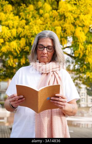 Femme mature lisant une histoire lors de la Journée mondiale du livre. Sant Jordi, tradition et culture de catalogne Banque D'Images
