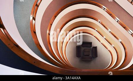 Vue de dessus de l'escalier intérieur en colimaçon avec des chaises noires au centre, au format écran large Banque D'Images