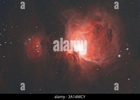 Une vue imprenable sur la nébuleuse d'Orion dans de superbes teintes rouges, avec ses vastes environs étoilés et mettant en valeur les détails étonnants de la nébuleuse Banque D'Images