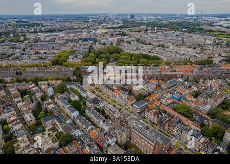 La vue aérienne d'Amsterdam, aux pays-Bas, met en valeur ses maisons emblématiques sur le canal, son architecture néerlandaise et ses excursions en bateau le long du front de mer, capturant le charme Banque D'Images