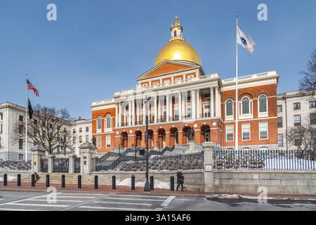 Boston, ma, États-Unis - 11 février 2025 - Une femme marchant devant la Massachusetts State House par un jour d'hiver clair Banque D'Images
