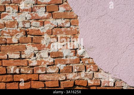 Beauté altérée – mur de briques roses fissurées. Banque D'Images