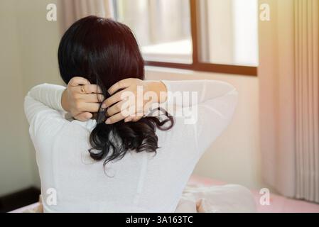 Femme âgée malade touchant le cou, ayant des douleurs malheureuses aux épaules et au cou, ressentant des douleurs sévères au cou. Vue arrière, espace de copie. Banque D'Images