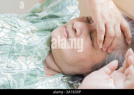 Vue rapprochée vue de la tête gros plan femme âgée allongée dans le lit à la maison, couvrant les yeux avec le bras, essayant de s'endormir. Concept de troubles du sommeil. Banque D'Images