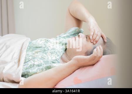 Image de vue latérale de la femme asiatique âgée déprimée regardant bouleversée pensant à la vie, concept de troubles de santé Banque D'Images