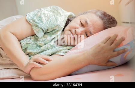 Femme âgée inquiète souffrant d'insomnie. Vieille femme couchée dans le lit avec les yeux ouverts. Femme mature incapable de dormir à la maison. Banque D'Images