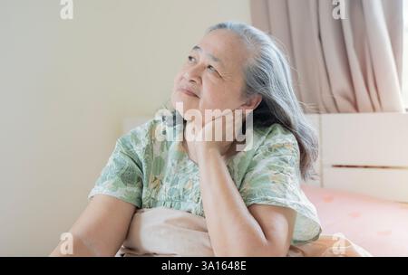 Femme asiatique senior, douleur au cou et stress dans la chambre à coucher à la maison de blessure à la colonne vertébrale, fibromyalgie et ostéoporose. Banque D'Images