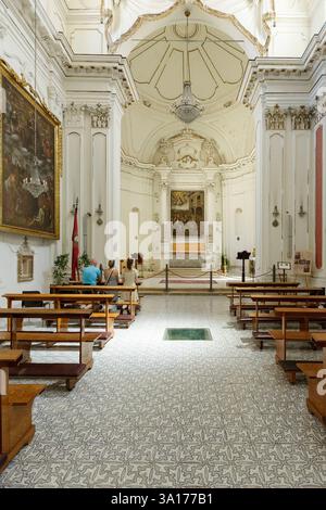 Italie, Sicile, île d'Ortigia classée au patrimoine mondial de l'UNESCO, Syracuse, Piazza Duomo (place du Duomo), église Santa Lucia alla Badia reconstruite entre 1695 et 1703 par l'architecte Luciano Caracciolo en style baroque tardif aujourd'hui une église désconsacrée transformée en centre d'exposition, le chœur et le maître-autel avec une peinture réalisée en 1579 par Deodata guinaccia, élève de la Carave, représentant Sainte Lucie conduite au martyre Banque D'Images