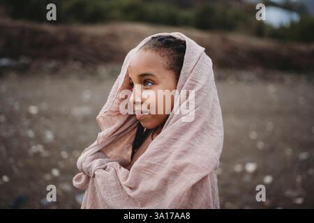 Belle fille noire avec écharpe sur sa tête à l'extérieur dans la campagne Banque D'Images