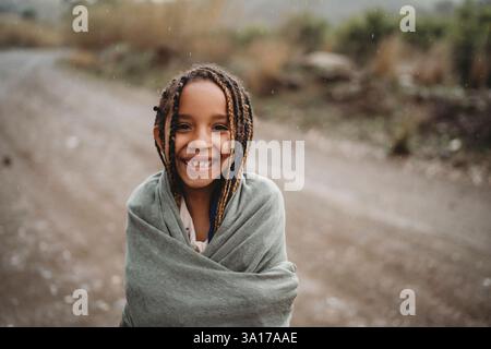 Filles noires souriantes dansant sous la pluie dans la campagne Banque D'Images