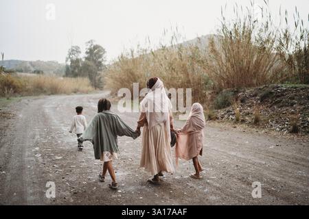 Vue arrière de la famille noire marchant dans la campagne jour de pluie Banque D'Images