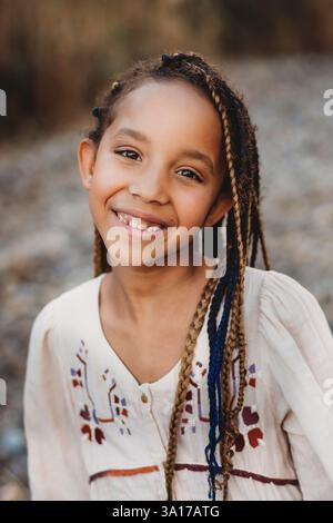 Fille multiraciale de race mixte noire souriante dans les champs d'été Banque D'Images