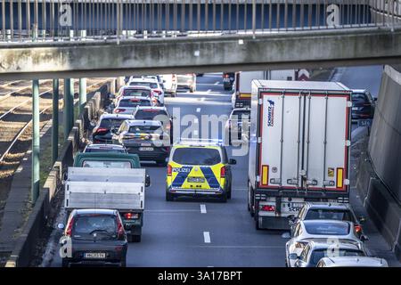 Embouteillage sur l'autoroute A40, voie d'urgence, véhicules à gauche et à droite, voiture de patrouille de police avec feux bleus clignotants et sirène, Essen, Nord R. Banque D'Images