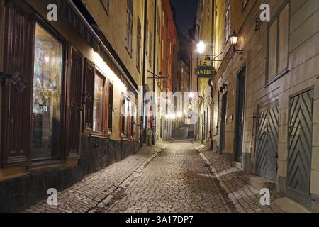 Étroite ruelle pavée illuminée la nuit avec de vieux bâtiments charmants, hiver, Gamla Stan, vieille ville, Stockholm Suède Banque D'Images