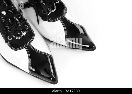 Orteils de chaussures blanches noires laquées fantaisie sur fond blanc Banque D'Images
