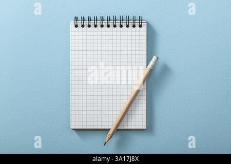 Bloc-notes et crayon en bois sur fond bleu Banque D'Images