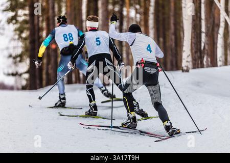 vue arrière des skieurs de groupe en montée dans une course de ski de fond Banque D'Images