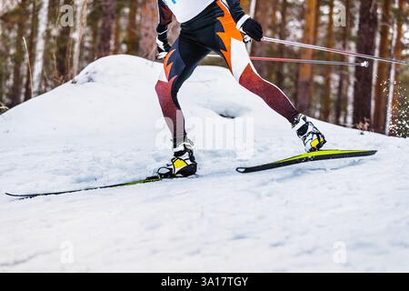 jambes skieur athlète et bâtons de ski, éclaboussures de neige derrière Banque D'Images