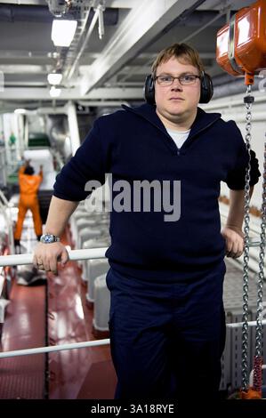 2ème / deuxième ingénieur du navire porte-conteneurs MS Flintercape à l'intérieur de la machine du navire et salle des machines lors d'un voyage de Rotterdam, pays-Bas vers Sundsvall, Suède avec une cargaison de conteneurs. MR=OUI Banque D'Images