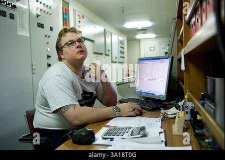 Deuxième / deuxième ingénieur dans la salle de contrôle des moteurs du navire MS Flinetercape lors d'un voyage de Rotterdam, pays-Bas à Sundvall, Suède. MR=OUI Banque D'Images