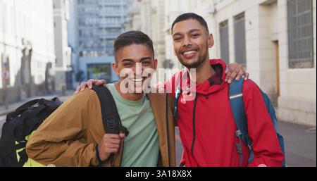 Heureux couple gay biracial embrassant dans la rue Banque D'Images
