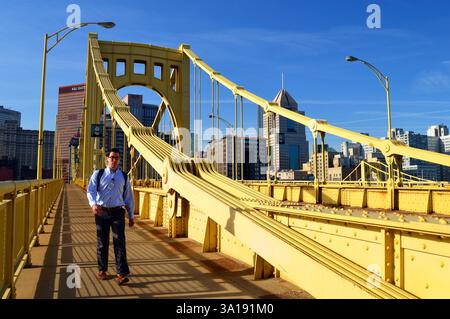 Un jeune homme traverse le pont jaune de la Sixth Street, également connu sous le nom de pont Roberto Clemente, à Pittsburgh, en Pennsylvanie Banque D'Images