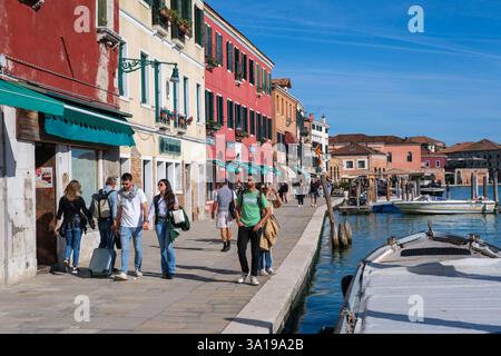 Venise, Italie - 12 octobre 2024 : les touristes se promènent le long de la promenade animée du front de mer de Murano, bordée de bâtiments colorés, de boutiques et de restaurants Banque D'Images