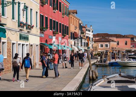 Venise, Italie - 12 octobre 2024 : les touristes se promènent le long de la promenade animée du front de mer de Murano, bordée de bâtiments colorés, de boutiques et de restaurants Banque D'Images