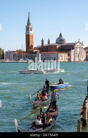 Venise, Italie - 12 octobre 2024 : gondoles et bateaux à moteur naviguant sur la lagune vénitienne près de San Giorgio Maggiore Banque D'Images