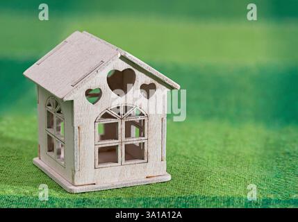 Maison modèle miniature toy blanc sur vert. Banque D'Images