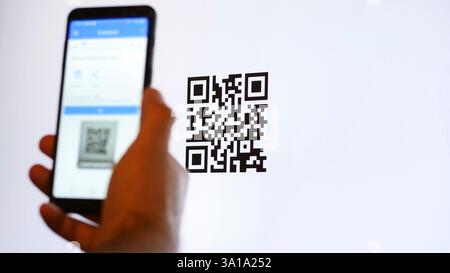 Scannez le code QR avec le smartphone sur l'écran de l'ordinateur. Banque D'Images