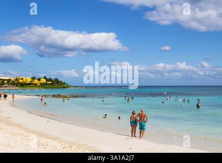Plage de sable blanc et vagues sur la côte de la mer des Caraïbes, Mexique. Riviera Maya. Image avec les touristes. Banque D'Images