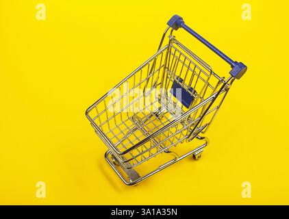 Mini panier sur fond jaune, de consommateurs concept, minimalisme, vue d'en haut. Banque D'Images
