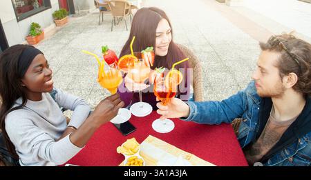 Trois amis toast avec un cocktail pour célébrer l'amitié. Banque D'Images