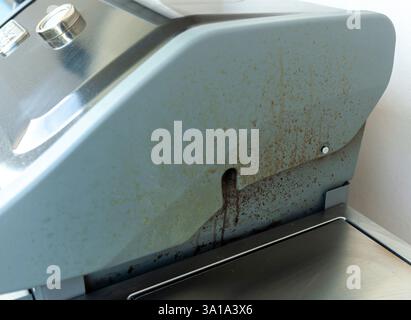 Graisse qui coule à l'extérieur du couvercle du gril en utilisant le brûleur latéral. Banque D'Images