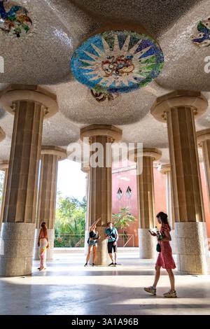 Touristes explorant la salle hypostyle à piliers conçue comme une place de marché, Park Güell par Antoni Gaudi, Barcelone, Espagne Banque D'Images