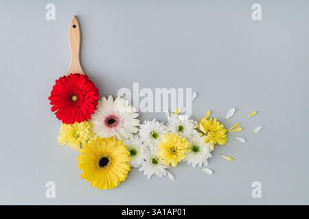 Composition de fleurs. Disposition à la mode faite de fleurs colorées et pinceau sur fond blanc. Concept créatif printemps et été. Pose à plat. Banque D'Images