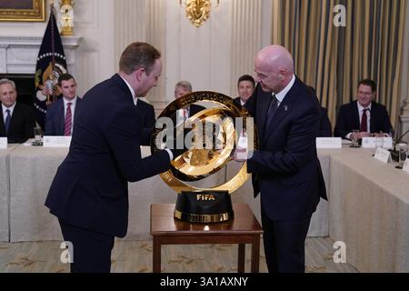 Washington, États-Unis. 07 mars 2025. Gianni Infantino, président de la Fédération internationale de Football Association (FIFA), affiche le Trophée de la Coupe du monde avant que le président des États-Unis Donald J Trump fasse des remarques au sommet de la Maison Blanche sur les actifs numériques (Crypto) dans la salle à manger d'État de la Maison Blanche à Washington, DC, États-Unis, le vendredi 7 mars, 2025.Credit : Chris Kleponis/CNP crédit : Abaca Press/Alamy Live News Banque D'Images
