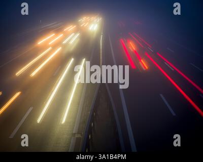 Traînées légères dans le brouillard sur l'autoroute Banque D'Images
