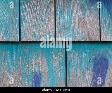 Gros plan de bardeaux en bois sur un cottage Cape Cod avec des taches de peinture Turquoise et bleu royal Banque D'Images